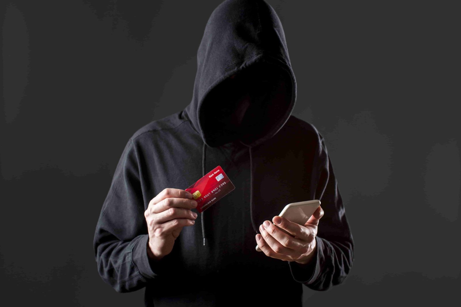 front-view-male-hacker-holding-smartphone-credit-card
